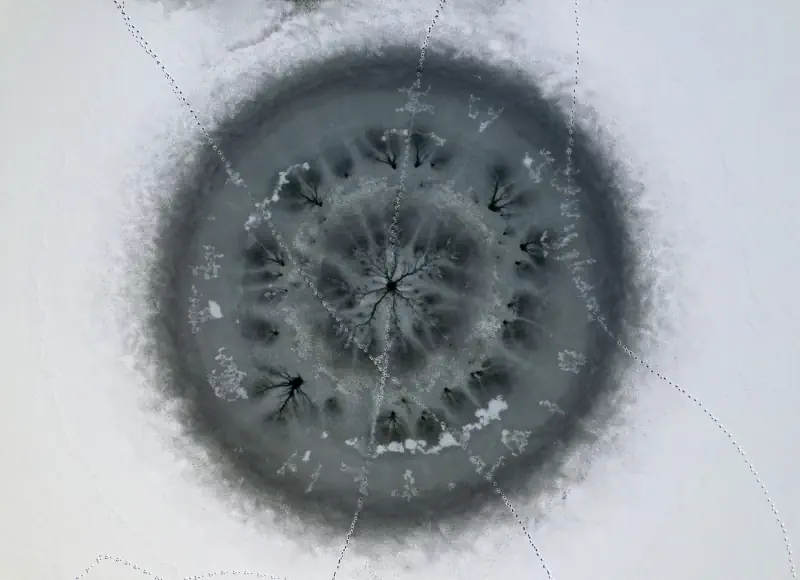 A circular frozen wetland pattern appears in pale ice.